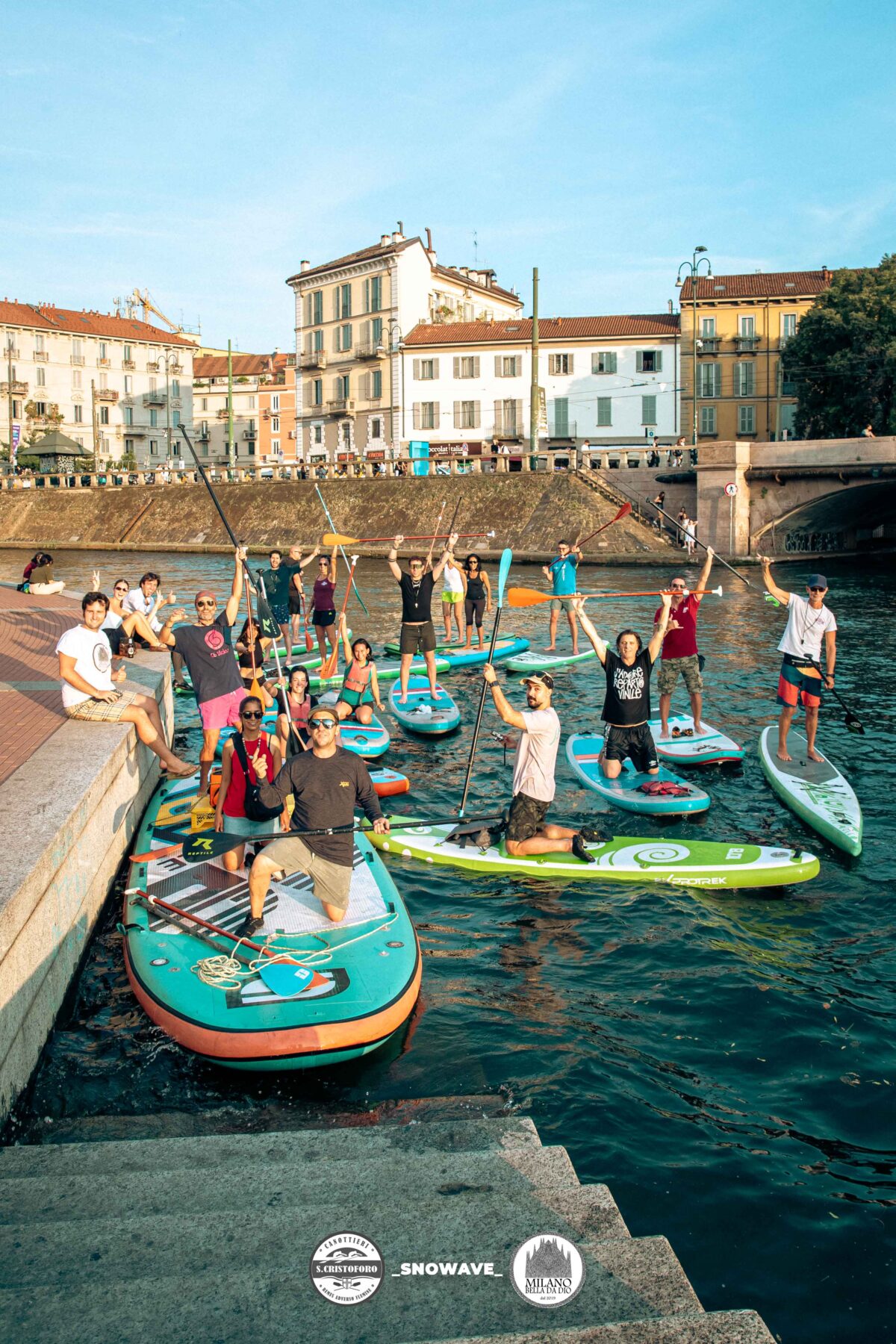 Persone che fanno sup sul naviglio di Milano al tramonto