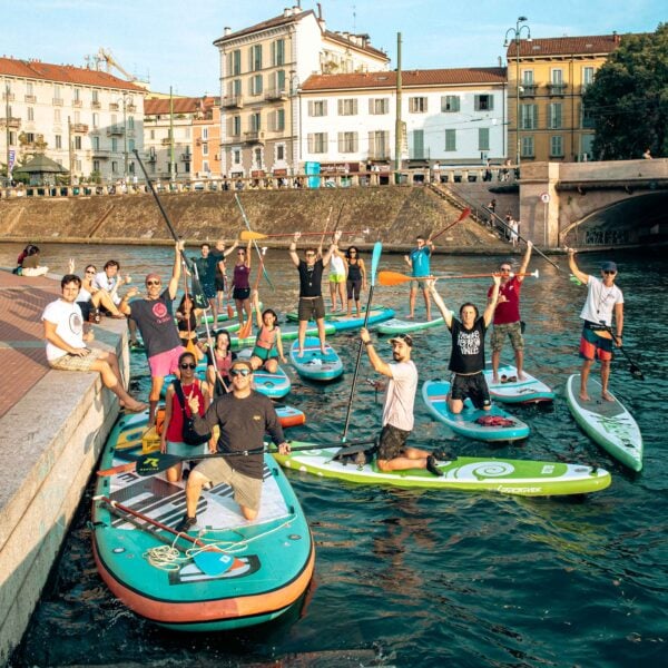 Persone che fanno sup sul naviglio di Milano al tramonto